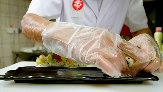 男厨师在厨房用托盘摆放寿司