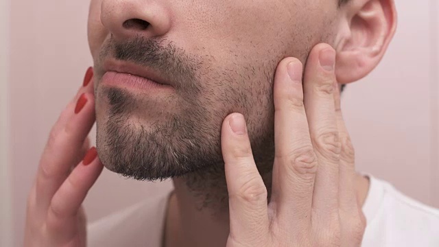 剃须后男女用手触摸脸部