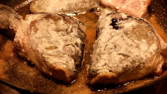 裹上面粉的鱼头在煎锅里用油煎