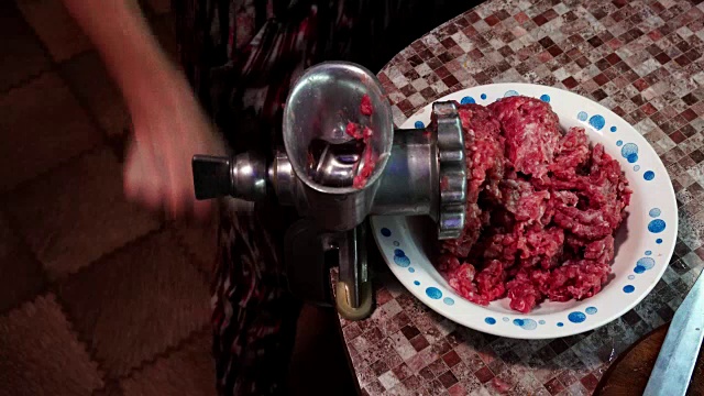 妇女正在用手磨碎肉
