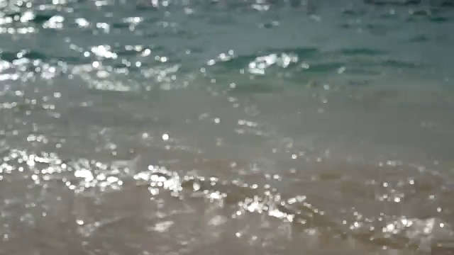 4 k。模糊的夏日海滩背景，海浪的柔软，清澈的水在白色的沙滩在普吉岛，泰国与海洋的声音。热带夏季海滩度假背景镜头