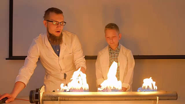 一个男孩的实验室助手用着火的扬声器做实验