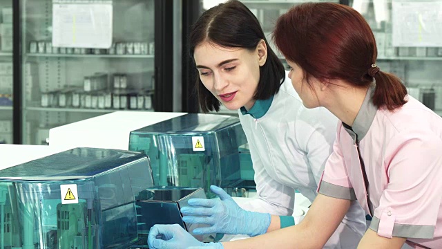 医疗保健科学家在实验室讨论分析机器