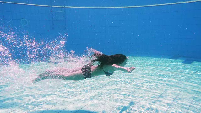 小女孩在游泳池里跳水