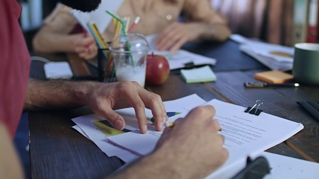 人们在商务会议上举手。合作伙伴在签约前阅读合同