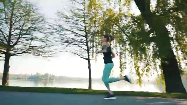 年轻的女运动员在公园里跑步。