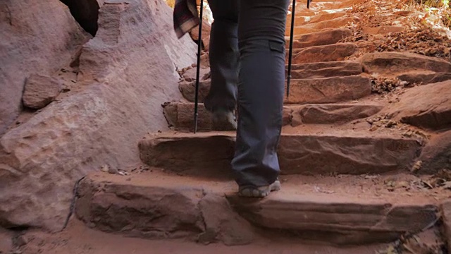 女人的脚艰难地攀登红色峡谷的石阶