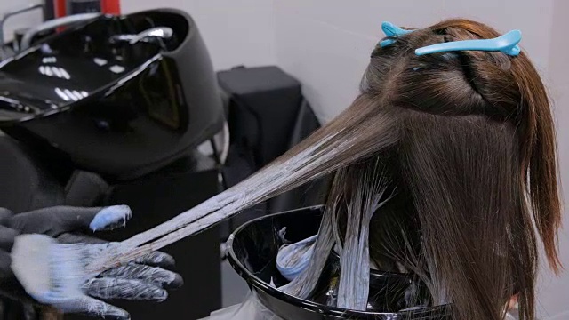 专业美发师在工作室为女性客户染发