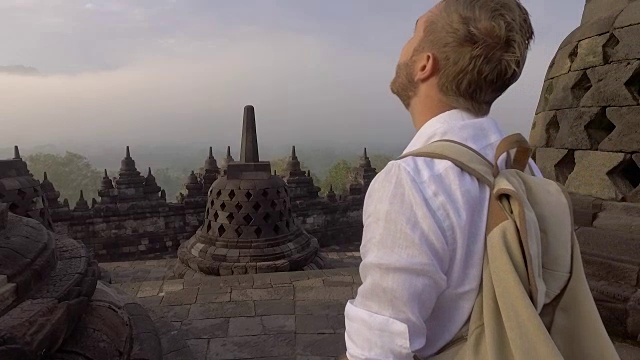 印尼婆罗浮屠寺，一名男子凝视日出的慢动作视频。人们旅行冒险的概念