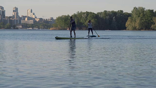Long Shot, Young Girl and Guy Swim on the River站在河边