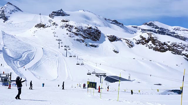 人们在马特霍恩克莱因的一个滑雪胜地滑雪，雪山和滑雪缆车的背景