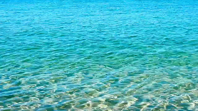 绿松石蓝色的海浪和海水在海滩上腐蚀夏天的背景。