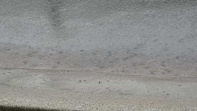 几滴大雨落在沥青上。热带降雨