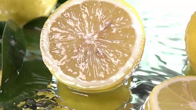柠檬半片碰到淡水表面。慢动作镜头