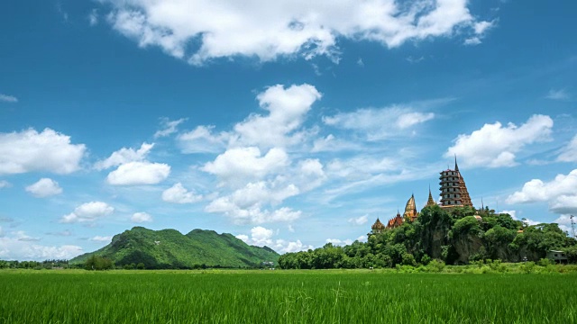 4k延时，在泰国北碧府老虎洞寺(Wat Tham Sua)美丽的天空和绿色的玉米地