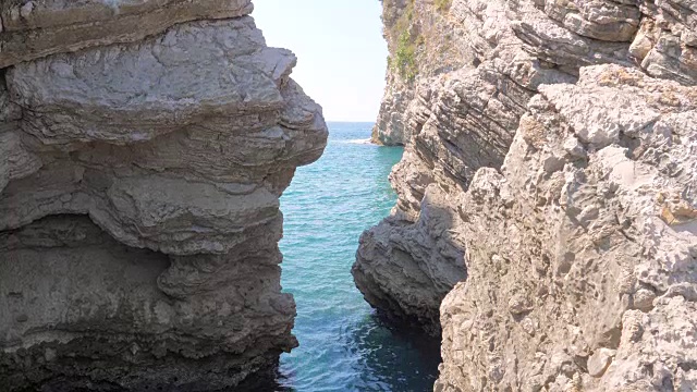 通过岩石狭窄的通道，泻湖碧蓝清澈的大海的景色