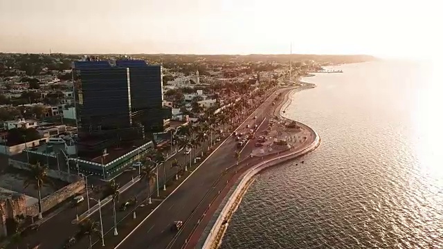 美丽的日落在大海和城市。Campeche Malecon和海上鸟瞰图。海滨的跑步机和自行车道