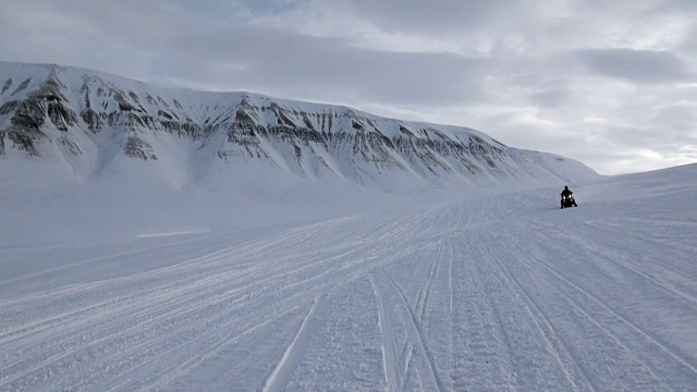 人们在北极斯匹次卑尔根斯瓦尔巴群岛的雪地摩托上探险。