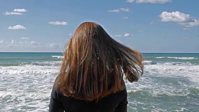 详情图-女孩长着红头发在沙滩上，海风吹着头发，白天拍。