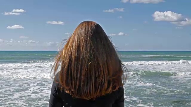 详情图-女孩长着红头发在沙滩上，海风吹着头发，白天拍。