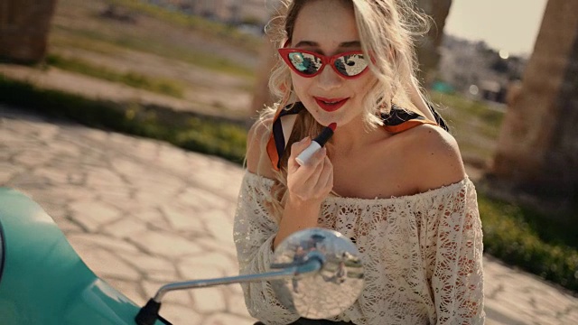 詳情圖-年輕時尚的女人用滑板車涂抹紅色口紅在意大利