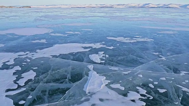 女人在贝加尔湖冰面上的旅行。观点的看法。冬岛之旅。女孩在冰岩石下行走。游客看着美丽的冰洞。背包客在大自然中休憩。