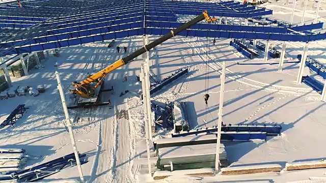 建设现代化工厂或厂房，工业区在冬季，从空中一览无余。现代化的厂房在白雪皑皑的田野上，新建了一座钢结构的商业建筑