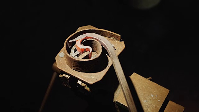 铁匠将烧红的金属棒弯曲