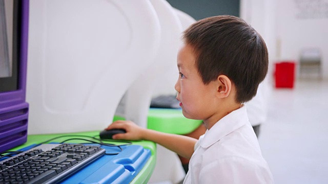 一名亚洲学童在科学活动中心使用电脑