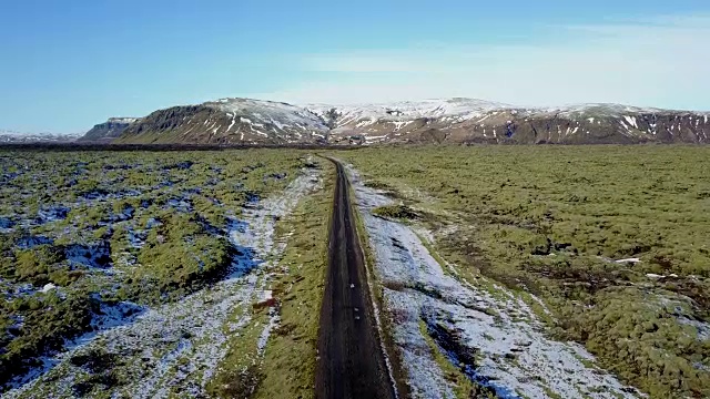 雪后的火山岩上，飞过长路青苔田。冰岛冬天的公路旅行