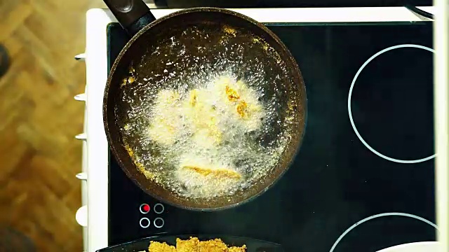 用煎锅煎鸭。浸入沸腾的油中。