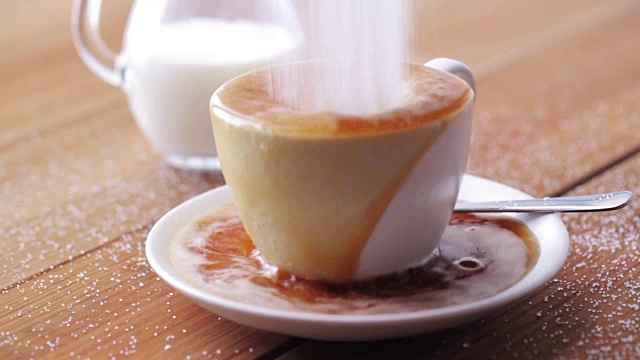 咖啡和糖洒在桌上的杯子里