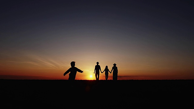 夕阳下幸福的一家人散步的剪影