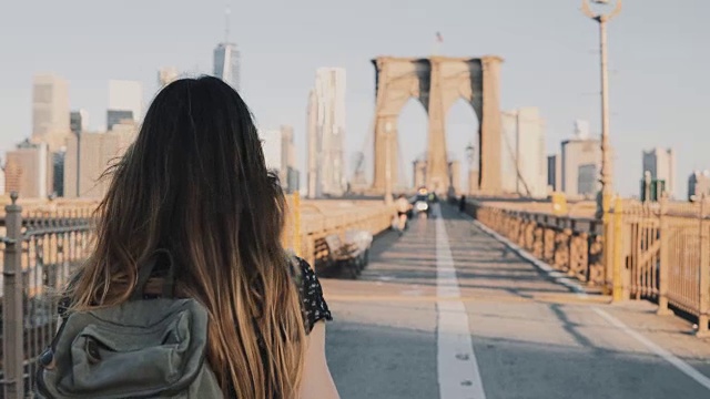 詳情圖-鏡頭跟隨一個(gè)背著背包的年輕女子沿著布魯克林大橋走，在一個(gè)美麗的陽(yáng)光燦爛的夏天4K