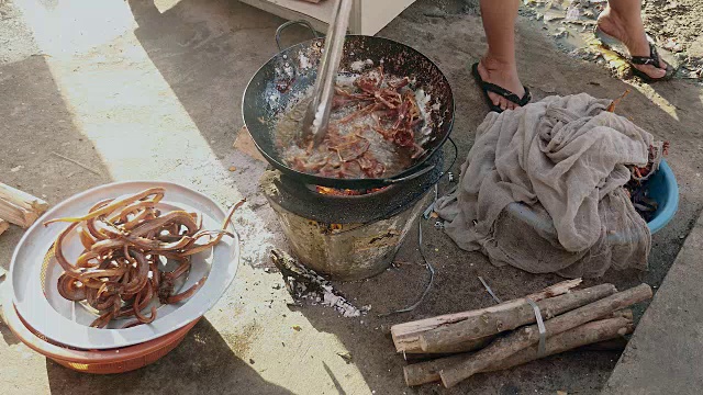 牛蛙被投入沸腾的油中烹饪(近距离)