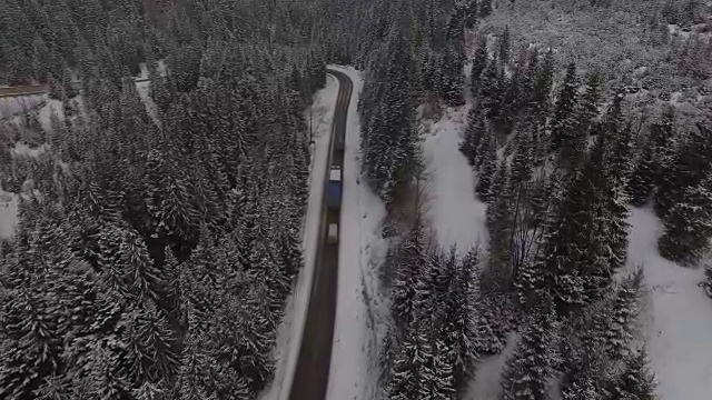 汽车行驶在雪地里的乡村道路上，无人机鸟瞰图