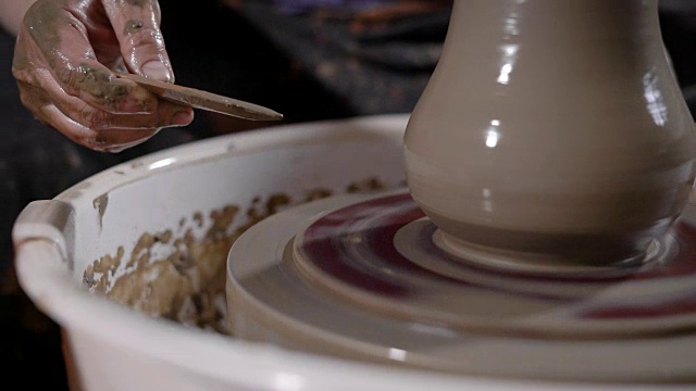 有才华的陶艺大师在作坊的陶轮上制作陶器