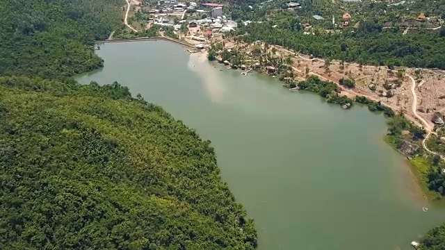 详情图-鸟瞰图绿色湖泊和大坝的背景山丘和山脉覆盖的热带森林。无人机飞越河流与大坝和岩石岸线在山区