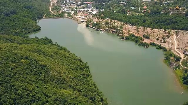 详情图-鸟瞰图绿色湖泊和大坝的背景山丘和山脉覆盖的热带森林。无人机飞越河流与大坝和岩石岸线在山区