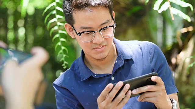 两个快乐男人在手机上玩游戏的镜头