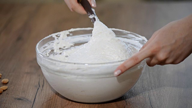 详情图-在糕点店，厨师用铲子在碗里搅拌马卡龙面糊或奶油。