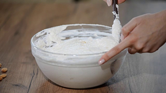 详情图-在糕点店，厨师用铲子在碗里搅拌马卡龙面糊或奶油。