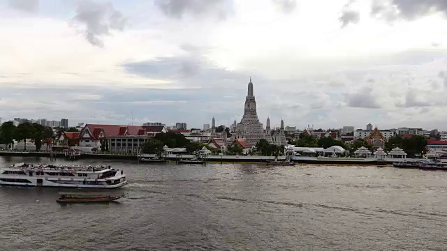 时间流逝的Wat Arun temple或与移动的云和阳光，湄南河的水运输