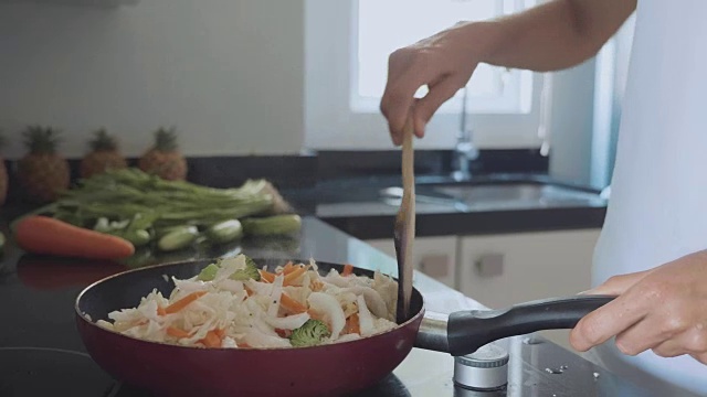 女人在煎锅上拌菜，特写