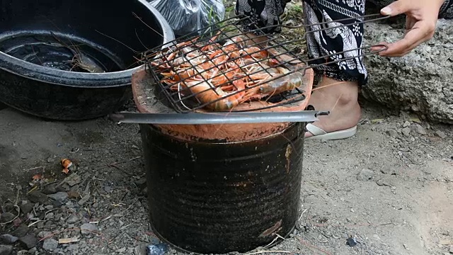 泰国妇女烹饪烤虾或对虾在火炉泰国风格在户外