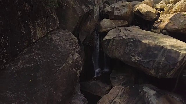 岩石瀑布在山区河流空中景观。流动的河水在山上瀑布在野生森林。无人机观看巨石和山川溪流