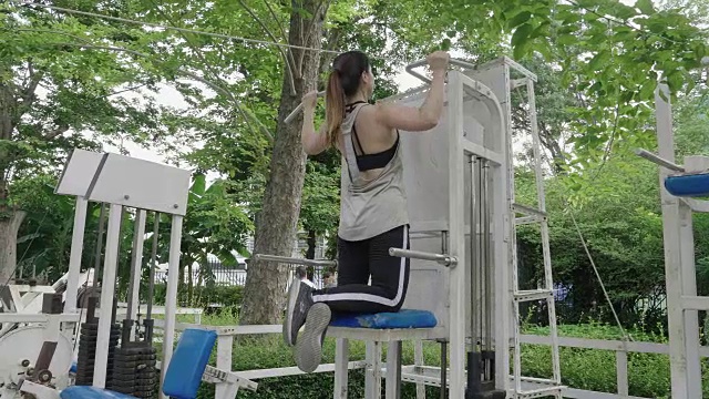 亚洲妇女拉动重量设备