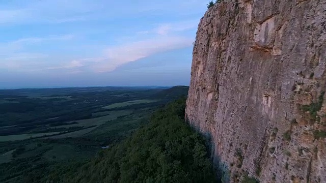 鸟瞰图沿着陡峭的垂直悬崖在山谷日落。