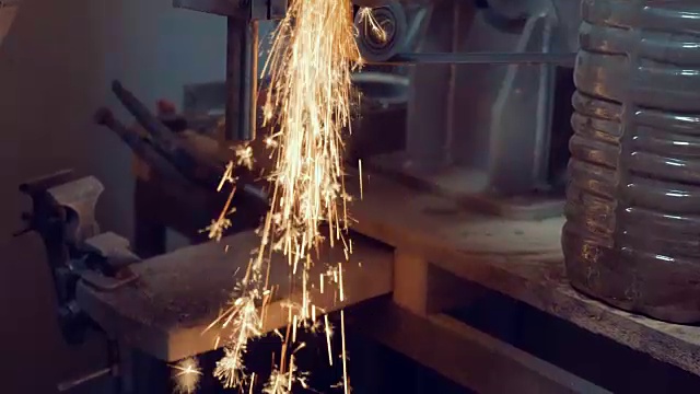 工业工人在冶金厂的车床上磨削金属零件