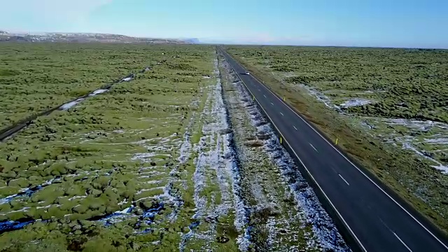 雪后的火山岩上，飞过长路青苔田。冰岛冬天的公路旅行